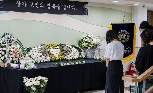 지난해 6월 부산대 인문관 앞에서 발생한 지게차 사고로 숨진 학생의 분향소에서 학부생들이 헌화하고 있다.  국제신문 DB