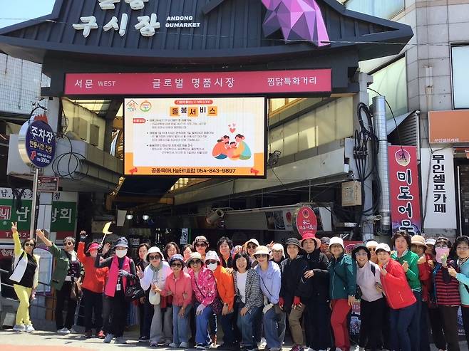 안동시가 추진 중인 전통시장 연계형 관광 프로그램 ‘왔니껴 투어’에 참가한 관광객들이 구시장 찜닭특화거리에서 기념 촬영하고 있다.   안동시 제공