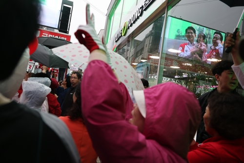 김문수 국민의힘 대선 후보가 지난 16일 충북 청주시 올리브영 청주타운 앞에서 집중 유세 도중 아이를 안은 모습을 한 여성이 바라보고 있다. [사진 출처 = 연합뉴스]