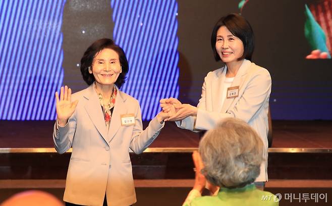 [서울=뉴시스] 조성봉 기자 = 이재명 더불어민주당 대선 후보의 부인 김혜경 여사와 김문수 국민의힘 대선후보의 부인 설난영(왼쪽) 여사가 12일 서울 중구 신라호텔에서 열린 중앙신도회 창립 70주년 기념식에서 손을 맞잡고 있다.(사진=조계종 제공) 2025.05.13.  *재판매 및 DB 금지 /사진=조성봉