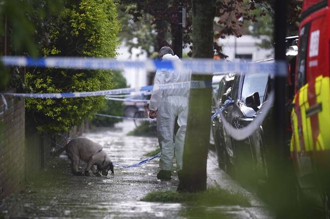12일(현지 시간) 영국 런던 북부 켄티시타운에 있는 키어 스타머 총리 사저에서 화재가 발생한 후 한 경찰관이 탐지견과 함께 주변을 조사하고 있다. 현지 경찰은 이날 새벽 1시경 총리 사저에서 불이 나 출동한 소방대가 30분 내로 진압했으며 인명 피해는 없다고 밝혔다. /AP=뉴시스