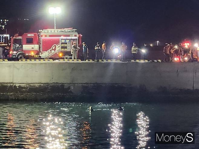여수해경 관계자들이 해상으로 추락한 승용차를 인양하고 있다/사진=여수해경 제공.