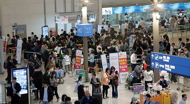 1일 인천국제공항 제1여객터미널 출국장 내 SK텔레콤 로밍센터에서 출국자들이 유심 교체를 위해 줄을 서고 있다. [연합]