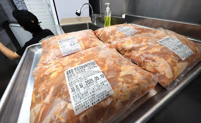 20일 서울 시내 치킨 판매점인 ‘짱닭치킨’에서 점주가 냉장고를 열어 순살 계육의 재고를 점검하고 있다.[연합]