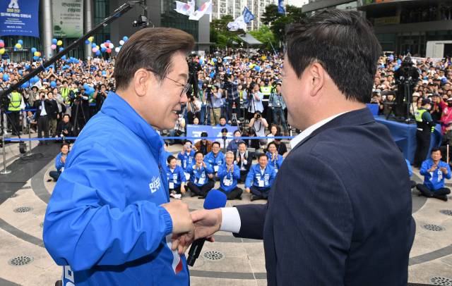 이재명 더불어민주당 대선 후보가 17일 광주 서구 김대중컨벤션센터에서 진행된 집중유세에서 김용남 전 새누리당 의원과 악수하고 있다. 김 전 의원은 이날 이 후보의 지지를 공식 선언했다. 광주=오승현 기자 2025.05.17