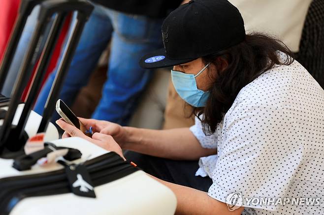 미국에서 자진출국해 온두라스로 돌아온 불법체류자  (산페드로술라 로이터=연합뉴스) 19일(현지시간) 미국에서 자진 추방 형식으로 송환된 불법체류자가 온두라스 산페드로술라 지역에서 휴대전화를 들여다보고 있다. 2025.5.19