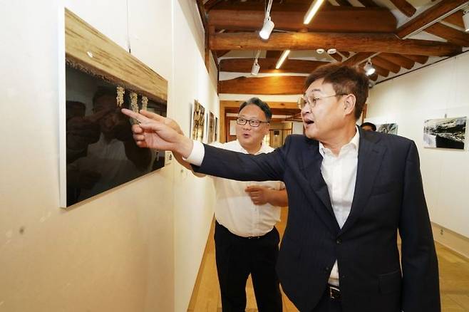 흰개미 피해 사진전 및 간담회에 참석한 정문헌 종로구청장이 피해 사진을 둘러보고 있다. 종로구 제공.