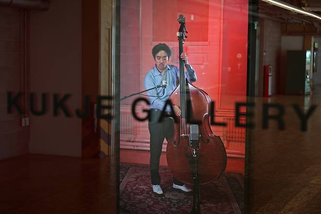 전시장 입구에서 만나는 영상. 콘트라베이스 연주자가 스크린 속에서 느슨한 블루스를 연주하고 있다. /뉴시스