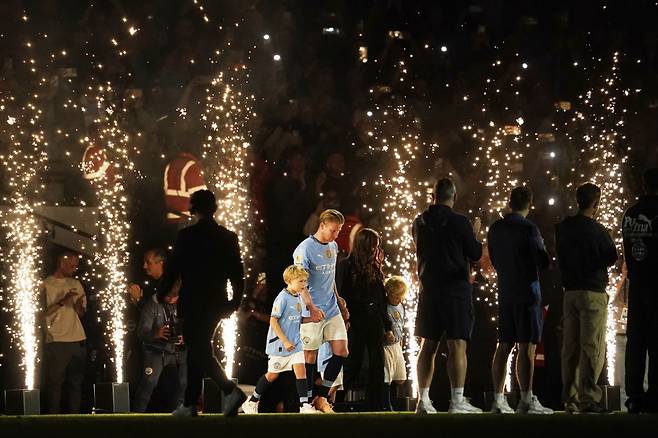 올 시즌을 끝으로 10년간 몸담았던 잉글랜드 프리미어리그(EPL) 맨체스터시티를 떠나는 케빈 더브라위너(가운데)가 가족들과 함께 맨시티 안방 구장인 에티하드 스타디움에서 걸어나오고 있다. 맨체스터=AP 뉴시스