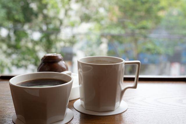 부산 중구 연경재의 음료와 디저트 뒤로 이팝나무가 흐릿하게 보이고 있다.