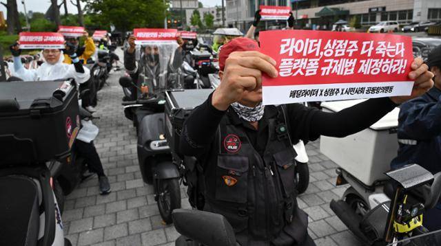 민주노총 공공운수노조 라이더유니온 지부와 라이더들이 지난해 8월 22일 서울 용산구 대통령실 앞에서 열린 배달 플랫폼 자율 규제 규탄 집회에서 '라이더 상점주 다 죽는다, 플랫폼 규제법 제정하라'라고 적힌 피켓을 들고 있다. 신용주 인턴기자