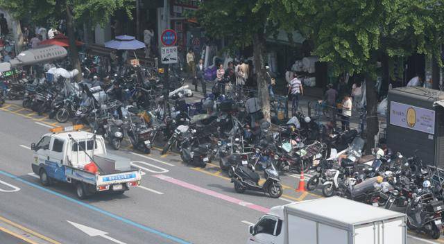 깊어지는 불황에 올해 들어 넉 달 연속으로 자영업자가 감소세를 보였다. 문을 닫는 자영업자가 늘면서 정부에 폐업 지원을 신청한 건수는 이미 연간 목표치인 3만 건에 육박했다. 통계청에 따르면 지난달 자영업자는 561만5,000명으로 작년 같은 달보다 6,000명 줄었다. 사진은 19일 서울 한 전통시장 부근에 배달 오토바이가 대기해 있는 모습. 연합뉴스