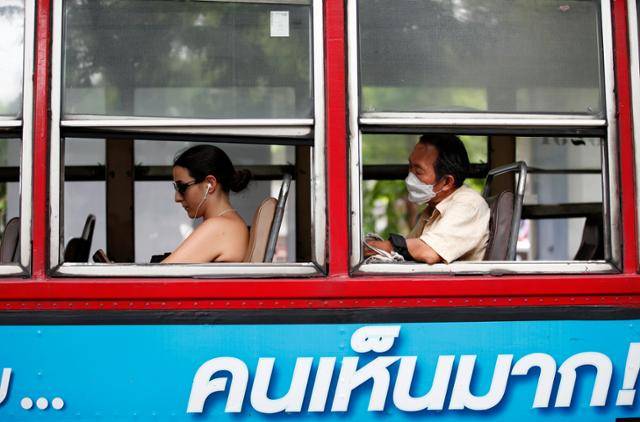 태국에서 코로나19 확산세가 거센 가운데 20일 방콕에서 한 남성이 마스크를 착용한 채 버스에 탑승하고 있다. 방콕=EPA 연합뉴스