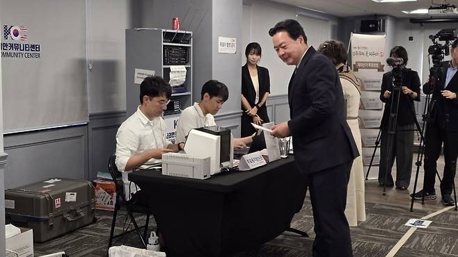 20일(현지시간) 미국 버지니아주 애넌데일 코리안커뮤니티센터에서 조현동 주미대사 내외가 투표용지를 배부받고 있다. 조 대사는 재외국민들의 적극적인 투표를 당부했다. /버지니아=이상은 특파원
