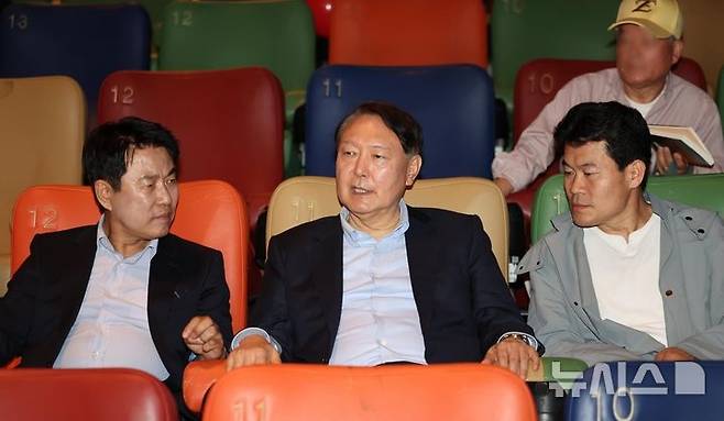Former President Yoon Suk Yeol speaks with film producers Lee Yeong-don and Jeon Han-gil at a theater in Seoul’s Dongdaemun District before watching “Korean Election Fraud, God’s Will?” on Wednesday. (Newsis)