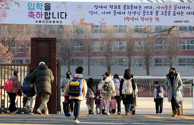 Elementary school students walk into their schoolyard in downtown Seoul in March 2024. [NEWS1]