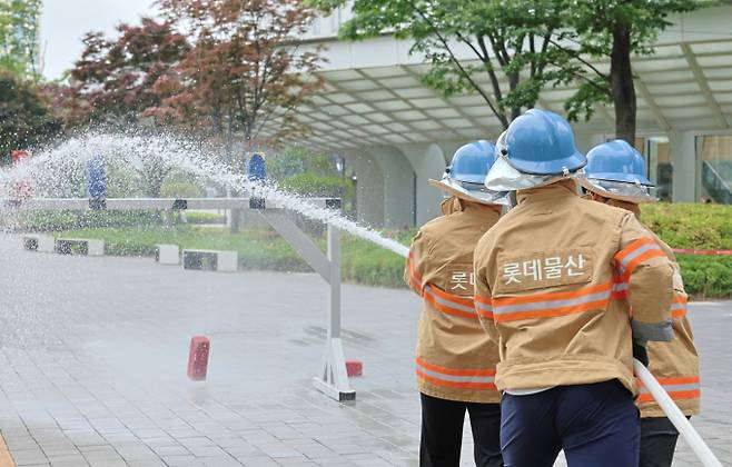 롯데물산 '2025 소방경진대회' 참가자들이 속도방수 경연을 펼치고 있다. /사진=롯데물산