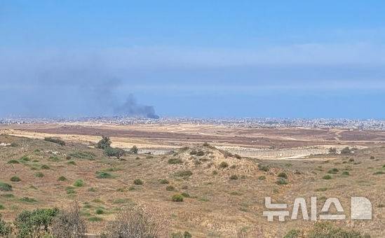 [스데로트=뉴시스]김난영 기자 = 21일(현지 시간) 이스라엘 남부 스데로트에서 바라본 가자 지구 모습. 건물 사이에서 검은 연기가 피어오르고 있다. 2025.05.21.