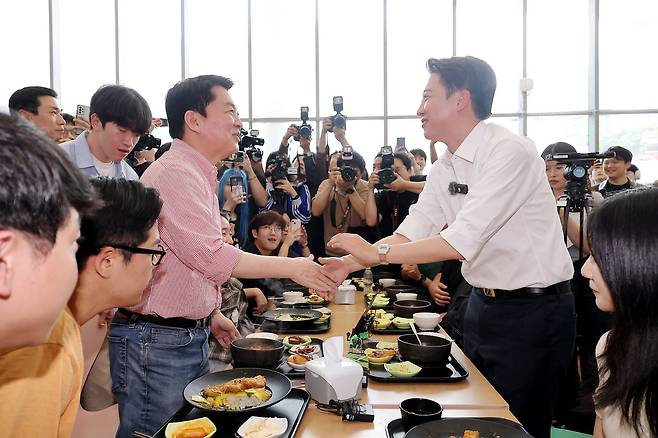 개혁신당 이준석 대선 후보가 21일 '학식먹자 이준석' 행사가 열린 경기 성남시 가천대학교 글로벌캠퍼스에서 행사에 참여한 국민의힘 안철수 의원과 만나 악수를&nbsp;하고 있다. 성남=연합뉴스