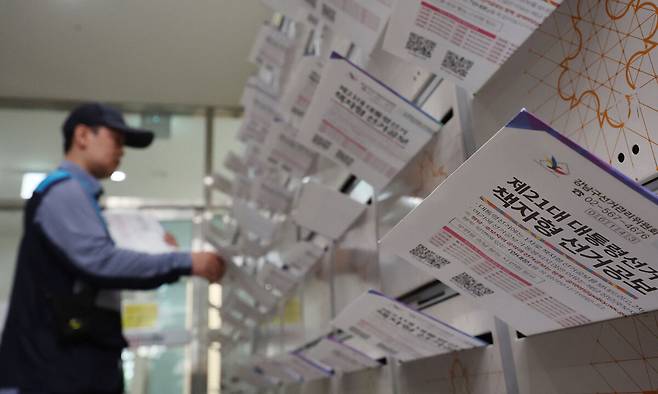 지난 19일 서울 강남구 한 오피스텔에서 우체국 집배원이 제21대 대통령선거 책자형 선거공보물을 우편함에 넣고 있다. 연합뉴스