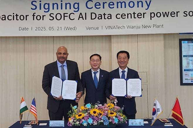 비나텍㈜ 성도경 대표(오른쪽)와 미국 블룸에너지 사티쉬 치투리(Satish Chitoori) 최고운영책임자(COO)가 21일 전북 완주 비나텍 제2공장에서 인공지능(AI) 데이터센터용 슈퍼커패시터 공급 계약을 체결한 뒤 계약서를 들어 보이고 있다. 가운데는 전북도 노홍석 행정부지사. 전북도 제공