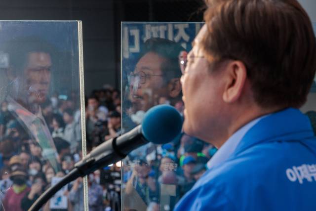 이재명 더불어민주당 대선 후보가 21일 자신의 지역구인 인천 계양구 계양역에서 지지를 호소하고 있는 가운데 방탄유리에 이 후보의 모습이 반사되고 있다. 인천=오승현 기자 2025.05.21