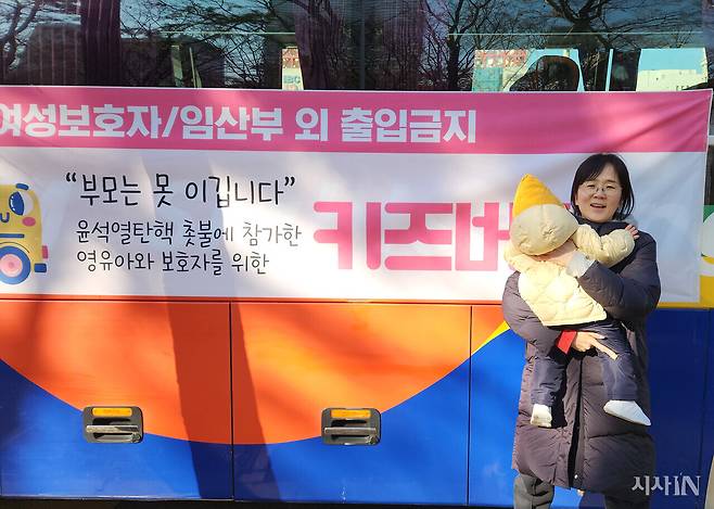 2024년12월14일 서울 여의도 국회 집회에 나온 ‘키즈버스’ 앞에서 권순영씨와 안지우양이 서있다. ⓒ시사IN 김동인