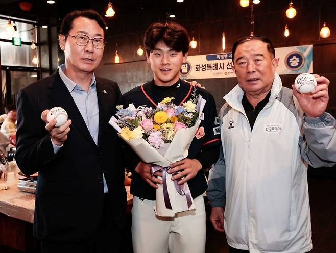 롯데 자이언츠에 입단하는 박찬형(가운데)이 프로 진출 후 본인의 사인 1호, 2호 공을 화성특례시 정명근 시장(왼쪽)과 박종선 화성시체육회장(오른쪽)에게 전달하는 모습.  /사진=화성시 코리오 독립야구단 제공