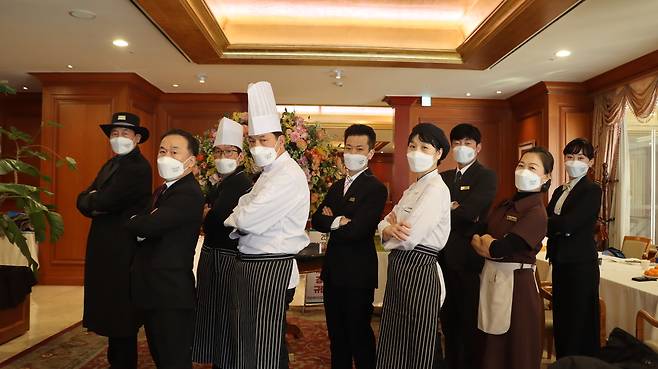 세종호텔노조 조합원들이 2021년 12월 정리해고 후 호텔 로비에서 농성하며 각자의 유니폼을 입고 단체 사진을 찍었다. 고진수씨(왼쪽)는 조리사 복이 아닌 도어맨 복장을 했다. 고씨는 “소수이고, 진급도 안 되고 맨날 월급이 깎였지만 회사 안에서는 우리가 제일 당당했다. 다들 눈치 보듯 밥 먹고 쫓기듯 다시 일하러 가는데 우리는 점심시간 다 지켰다”고 했다. 스튜디오R 양동민 작가