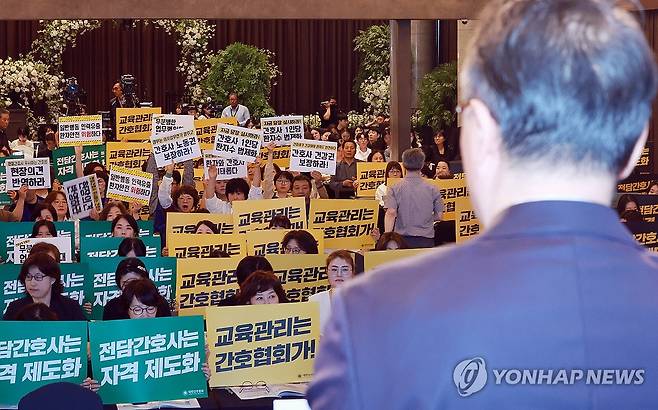 박민수 2차관 개회사 들으며 피케팅하는 간협과 의료연대본부 (서울=연합뉴스) 신현우 기자 = 박민수 보건복지부 제2차관이 21일 서울 용산구 피크앤파크 컨벤션 로얄홀에서 열린 간호법 제정에 따른 진료지원업무 제도화 방안 공청회에 참석해 개회사하는 가운데 대한간호협회 회원과 전국민주노동조합총연맹 공공운수노조 의료연대본부 조합원이 각각 피케팅하고 있다. 2025.5.21 nowwego@yna.co.kr