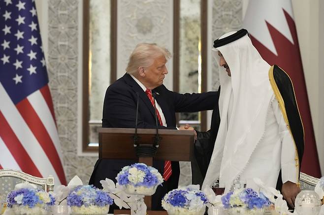 도널드 트럼프 미국 대통령이 14일(현지 시간) 카타르 도하에서 열린 국빈만찬 중 타밈 빈 하마드 알사니 카타르 국왕과 악수하고 있다. 2025.05.15.[도하=AP/뉴시스]
