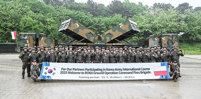 육군은 22일, 해외 주요 방산협력국 장병들을 대상으로 K-무기체계의 전술적 운용을 교육하는 '육군 국제과정' 현장 모습을 공개했다. 이번 훈련은 국제과정 최초로 천무 교육이 개설되었으며, 15일부터 2주간 폴란드 장병 16명이 교육훈련을 받고 있다. 사진은 천무 현장실습에 나선 폴란드군 교육생들이 기념사진을 촬영하고 있다. 육군 제공