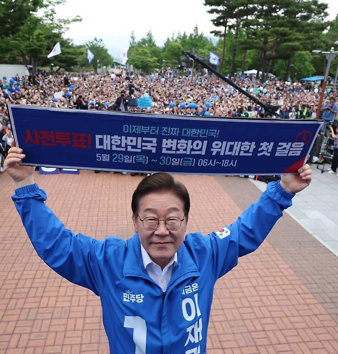 사전투표 독려하는 李 이재명 더불어민주당 대선 후보가 22일 경남 양산시 양산워터파크공원에서 열린 집중유세에서 사전투표 독려 현수막 모형을 들어 보이고 있다. 뉴시스