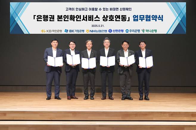 지난 21일 서울 중구 우리은행 본점에서 열린 ‘은행권 본인확인서비스 상호연동 업무협약’에 박형주 KB국민은행 스타뱅킹영업본부장(좌측 첫번째)를 비롯한 각 은행 관계자들이 기념촬영을 하고 있다. 국민은행 제공