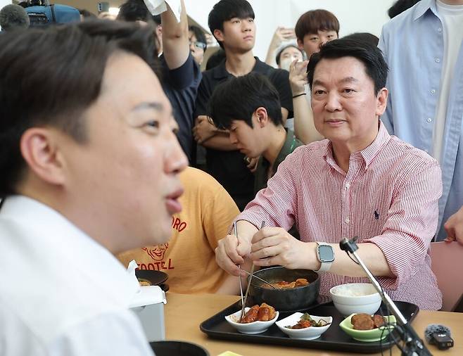 국민의힘 안철수 의원이 21일 경기 성남시 가천대학교 글로벌캠퍼스에서 열린 ‘학식 먹자 이준석\' 행사에 참석한 가운데 학생들과 대화를 나누는 개혁신당 이준석 대선 후보를 바라보고 있다. 연합뉴스