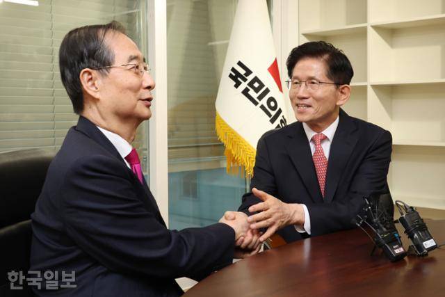 김문수(오른쪽) 국민의힘 대선 후보와 한덕수 전 국무총리가 11일 서울 여의도 국민의힘 당사에서 회동하며 악수하고 있다. 최주연 기자