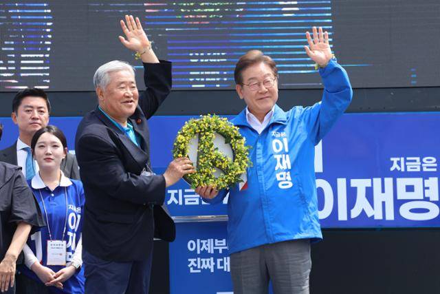 이재명 더불어민주당 대선 후보가 22일 제주시 동문로터리에서 제주 4·3 사건 유족에게 유채꽃으로 만든 '투표기호'를 선물로 받고 있다. 연합뉴스