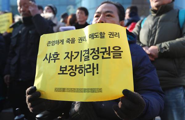 ▲ 2018년 12월17일 오후 서울역광장에서 열린 2018 홈리스 추모주간 선포 기자회견에서 참가자들이 홈리스의 사후 자기결정권 보장을 촉구하는 내용이 적힌 손피켓을 들고 있다. ⓒ연합뉴스