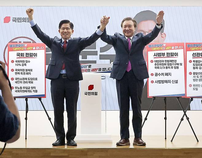 국민의힘 김문수 대선 후보와 손학규 전 민주당·바른미래당 대표가 22일 서울 여의도 국민의힘 중앙당사에서 열린 정치개혁 관련 긴급 기자회견에서 함께 손을 들어보이고 있다. <연합>