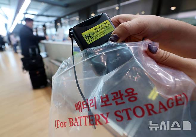 [서울=뉴시스] 김명년 기자 = 1일 인천국제공항 제2여객터미널 대한항공 체크인 카운터에서 관계자가 보조배터리에 스티커를 부착한 뒤 비닐봉지에 넣고 있다. 2025.03.01. kmn@newsis.com
