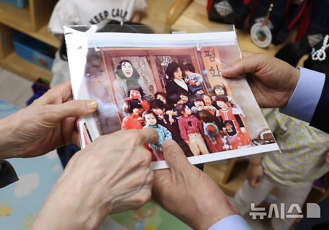 [광명=뉴시스] 고승민 기자 = 김문수 국민의힘 대선 후보와 설난영 여사가 22일 경기 광명시의 한 어린이집에서 아이들을 만나던 중 딸 동주 씨의 어린시절 사진을 보고 있다. 2025.05.22. kkssmm99@newsis.com