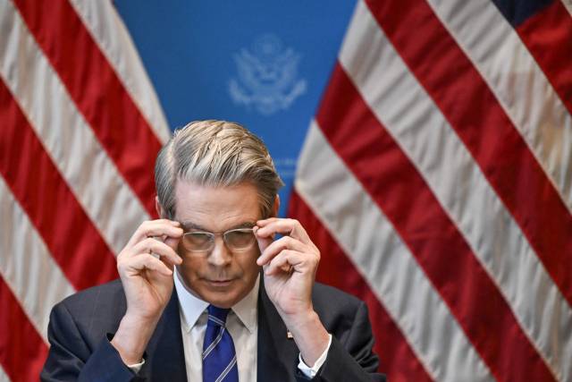 지난 12일(현지 시간) 스위스 제네바에서 스콧 베선트 미국 재무장관이 언론 브리핑에 앞서 안경을 고쳐쓰고 있다