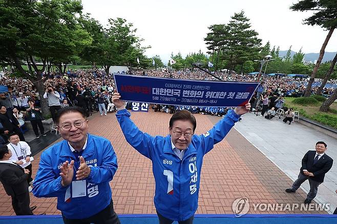현수막 들어 보이는 이재명 대선 후보 (양산=연합뉴스) 김인철 기자 = 더불어민주당 이재명 대선 후보가 22일 경남 양산워터파크공원에서 열린 집중유세에서 '사전투표! 대한민국 변화의 위대한 첫 걸음'이라고 적힌 현수막을 들어 보이고 있다. 2025.5.22 [공동취재] yatoya@yna.co.kr