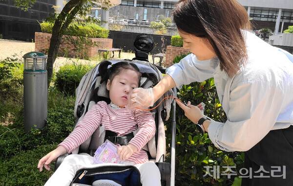 어머니 박씨가 봄이의 호흡기의 분비물을 제거하고 있다. ⓒ제주의소리