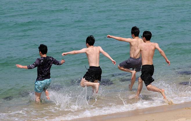 30도를 넘는 무더위가 찾아온 지난 20일 강원 강릉시 경포해변을 찾은 관광객들이 시원한 바다에 뛰어들고 있다. /연합뉴스