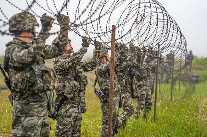 서북도서방위사령부는 지난 21일부터 23일까지 백령도와 연평도 등 서북도서 일대에서 서북도서의 군사대비태세를 유지하고, 합동작전 수행능력을 향상하기 위해 2025년 전반기 합동도서방어훈련을 실시했다.사진은 21일 해병대 6여단 장병들이 합동도서방어훈련 간 백령도 지역에 적 강점에 대비하여 철조망 장애물을 설치하고 있다. 해병대사령부 제공