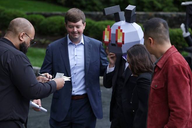 22일(현지시간) 미국 버지니아주 스털링의 트럼프 내셔널 골프클럽 입구에서 신원 미상의 만찬 손님(왼쪽 세번쩨)이 마스크를 쓰고 골프장 안으로 이동하고 있다.AFP연합뉴스