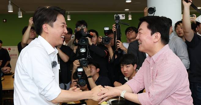 이준석 개혁신당 대선 후보(왼쪽)와 안철수 국민의힘 의원이 21일 경기 성남시 수정구 가천대학교 글로벌캠퍼스 학생식당에서 만나 악수하고 있다. (안철수 의원 페이스북 캡처) 있다.
