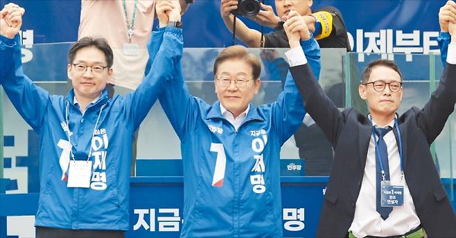 < 김경수와 유세 나선 이재명 > 이재명 더불어민주당 대선 후보(가운데)가 22일 경남 양산워터파크공원에서 열린 집중 유세에서 김경수 총괄선거대책위원장(왼쪽) 및 찬조연설자와 손을 잡고 시민들에게 인사하고 있다.  /연합뉴스