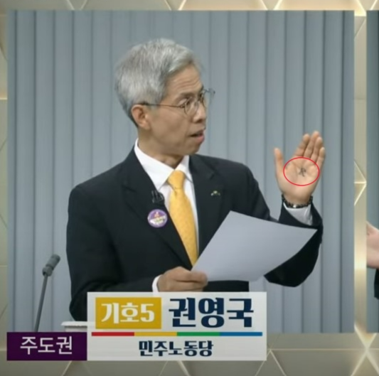 23일 TV토론에 참석한 권영국 민주노동당 대선 후보의 손바닥에 ‘백성 민(民)’자가 적혀 있다. TV토론 갈무리